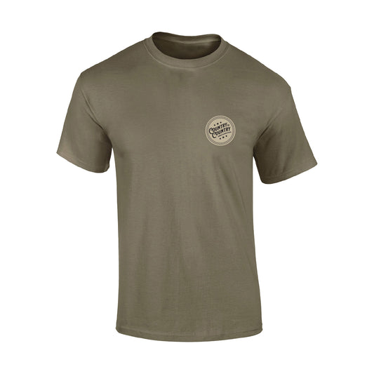 The 2025 Prairie Dust London T-Shirt from C2C Country To Country Store is an olive green short-sleeve tee with a small circular Built in the Country logo on the left chest, blending simple style and country-inspired design.