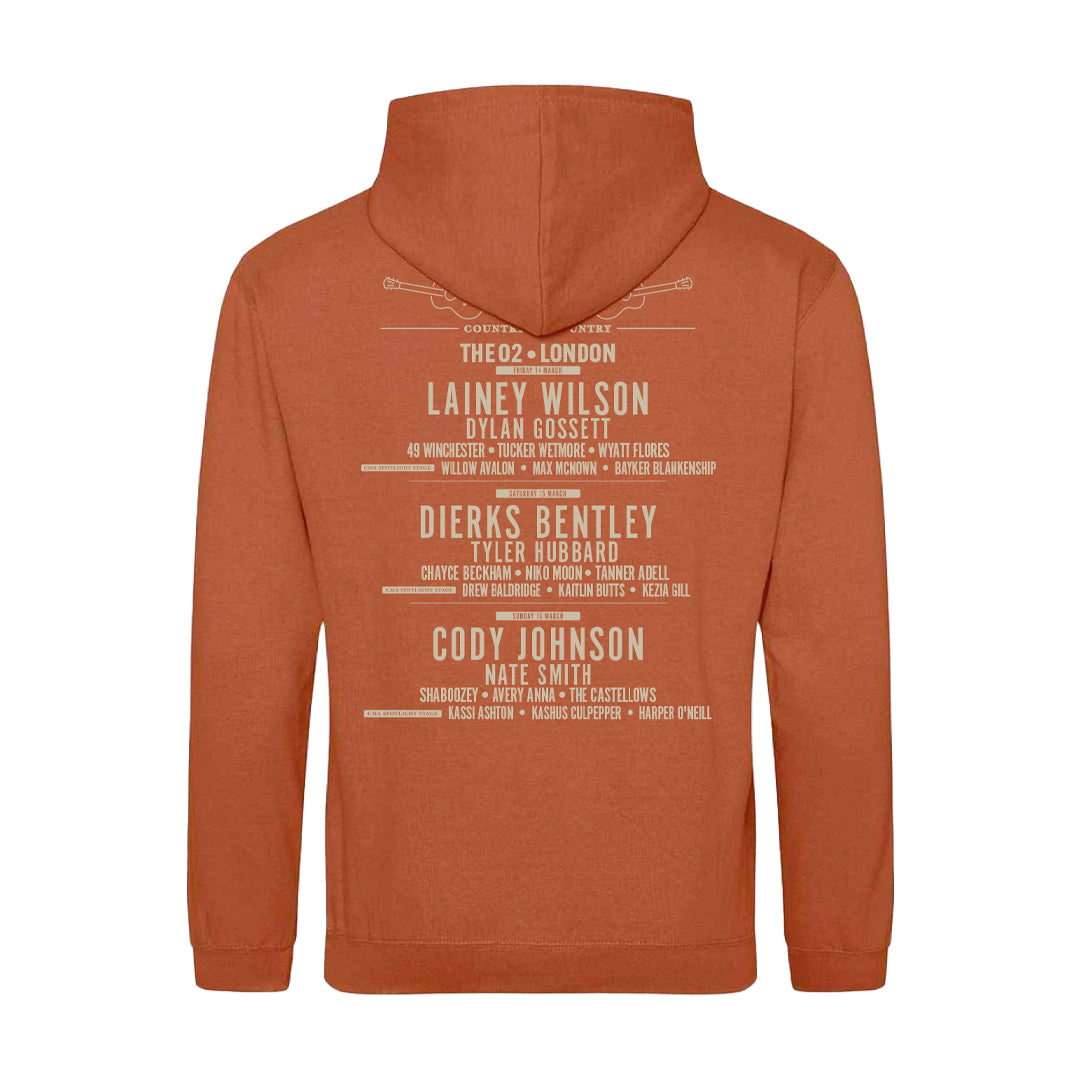 The 2025 Ginger Biscuit London Hoodie by C2C Country To Country Store is a brown hoodie featuring country music artists and venues like Lainey Wilson, Dierks Bentley, Cody Johnson, and The O2–London on the back.