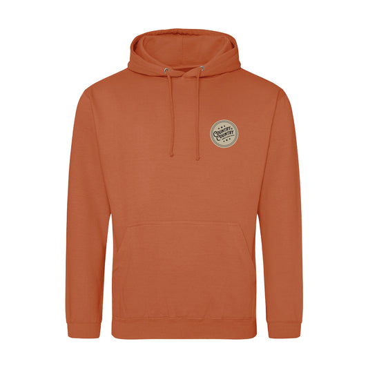 The 2025 Ginger Biscuit London Hoodie from C2C Country To Country Store features a rust color, front pocket, drawstring hood, and a left-chest patch reading “Caffeine & Comfort”—ideal for cozy, laid-back style and daily comfort.