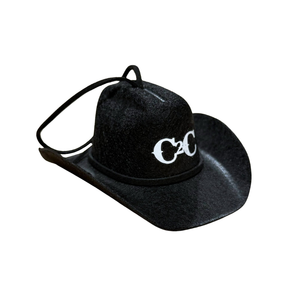 The C2C Country To Country Black Cowboy Hat Bauble is a small black hat with a chin strap and white “C C” lettering on the front, shown against a white background.
