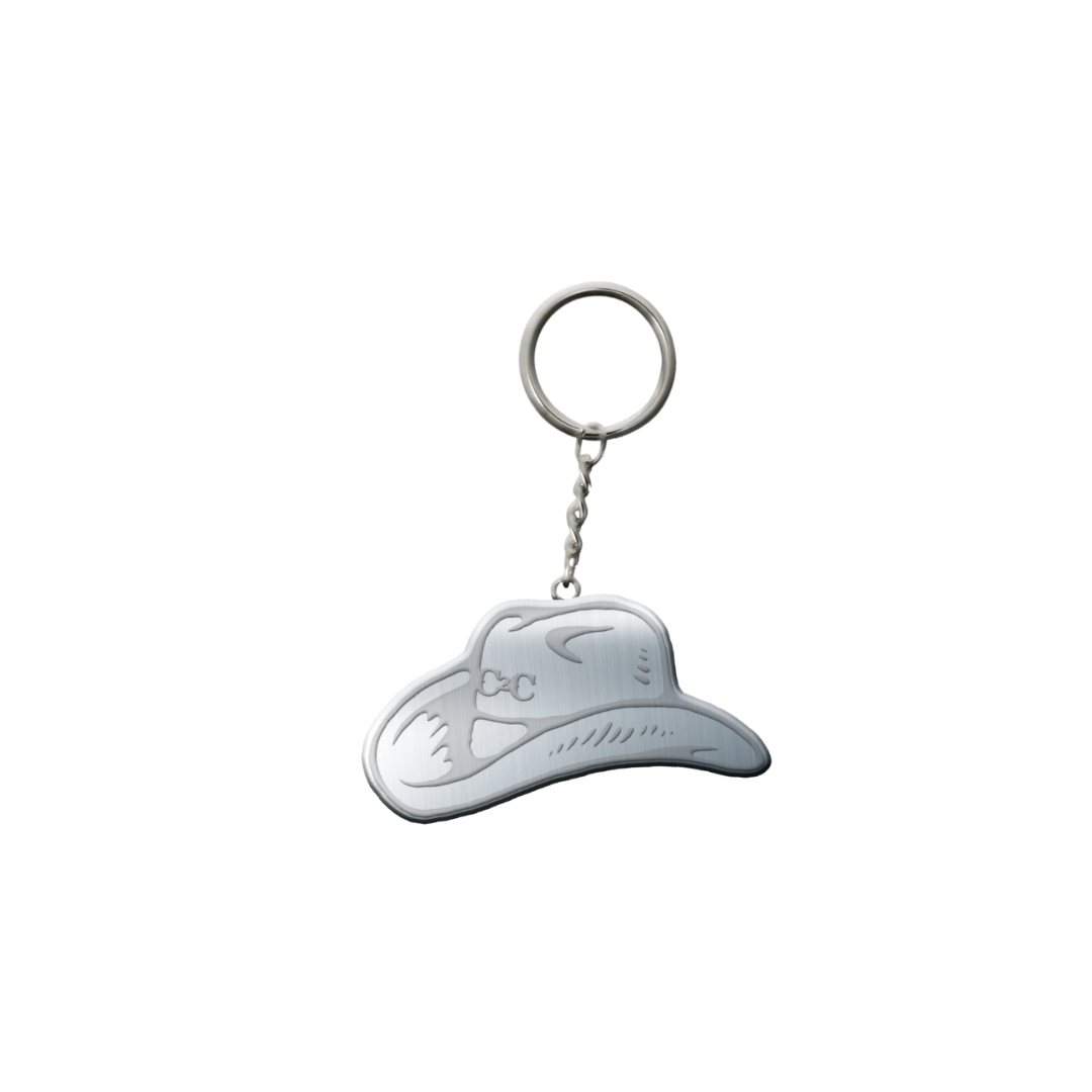 The 2026 Cowboy Hat Keyring features a silver hat with engraved details, attached to a round keyring by a short chain, and is shown on a white background for country festival style.
