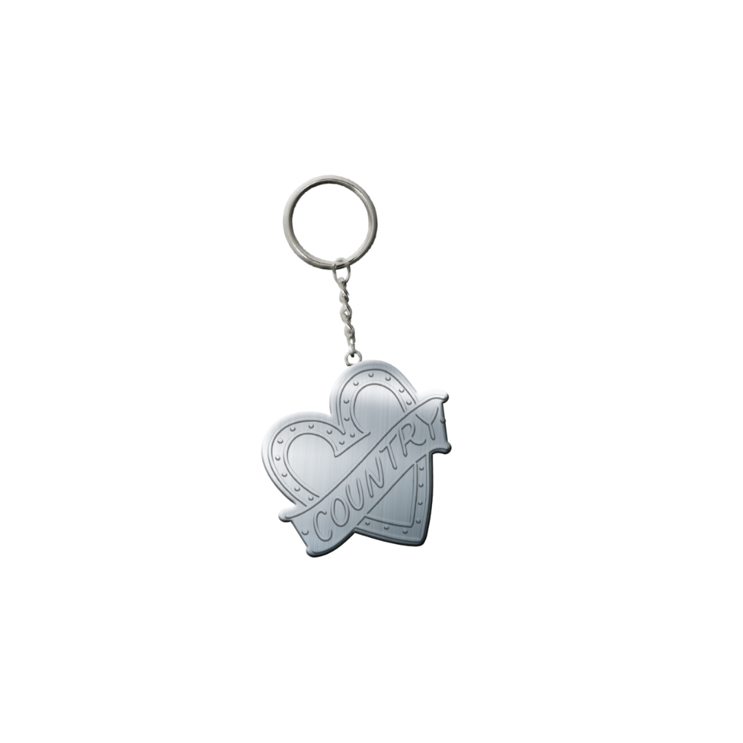 The 2026 I Heart Country Keyring features a silver heart-shaped pendant with a "COUNTRY" banner—perfect for country music fans. Isolated on white background.